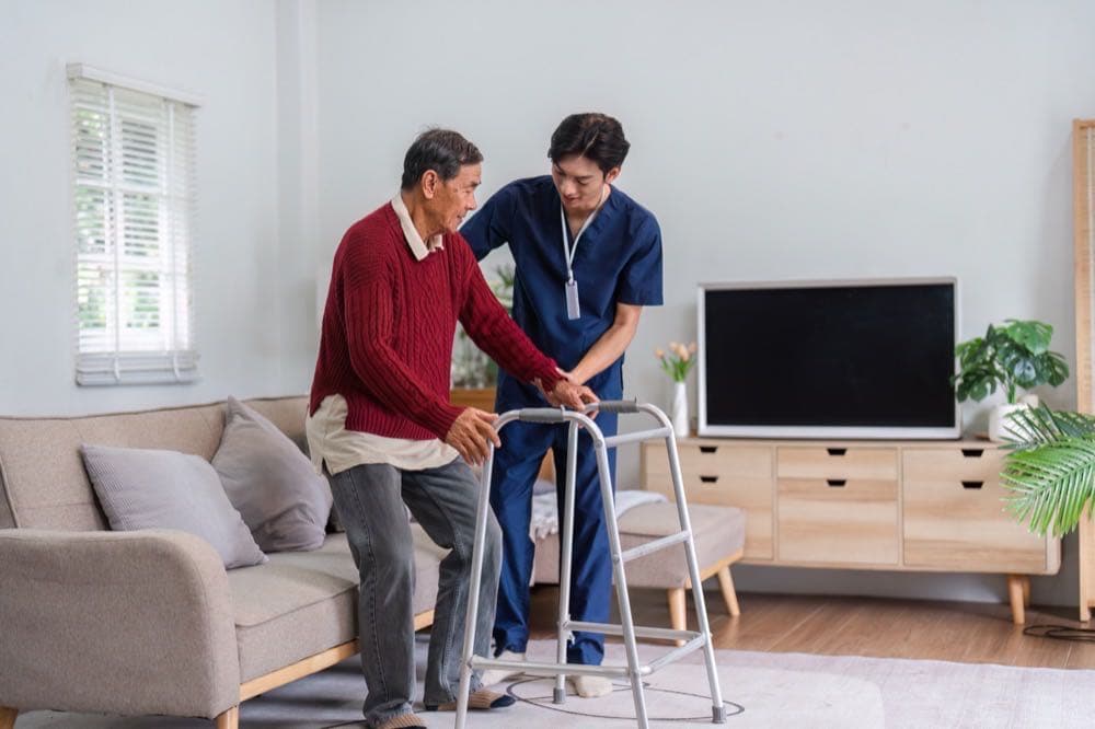 Caring nurse assisting an elderly resident in a senior living community