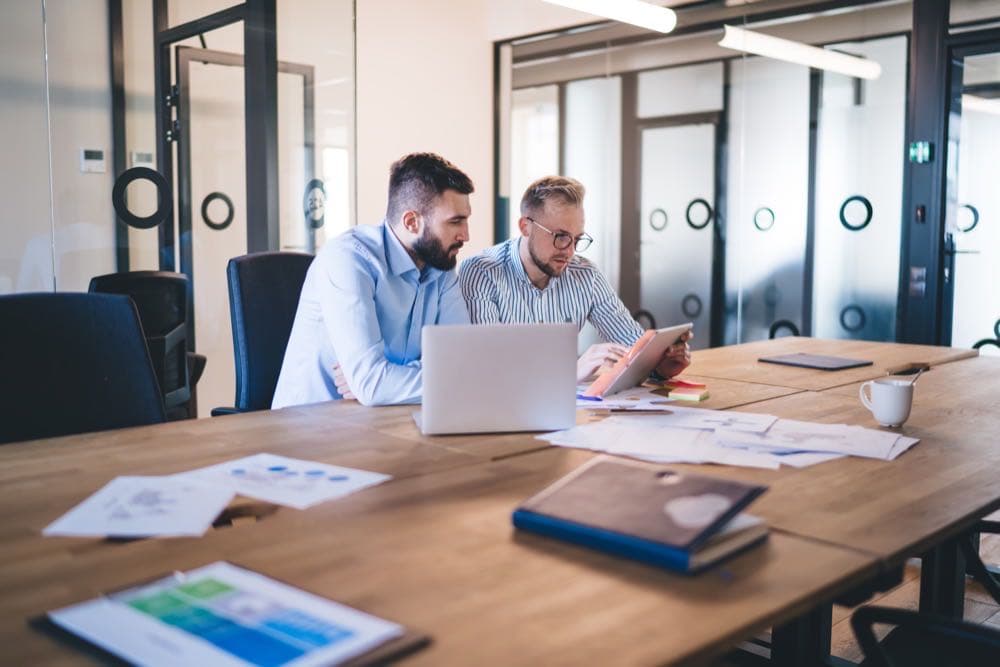 IT professionals reviewing a report together representing managed IT versus co-managed IT models