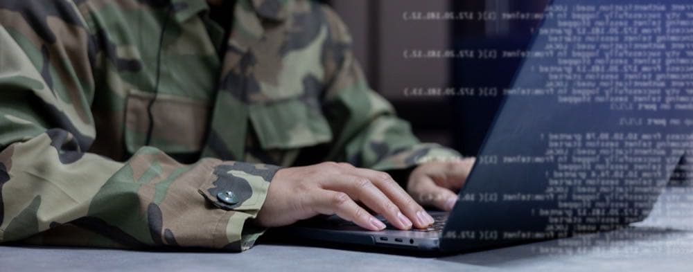 Close-up of a hand typing on a laptop keyboard representing CMMC readiness for defense subcontractors
