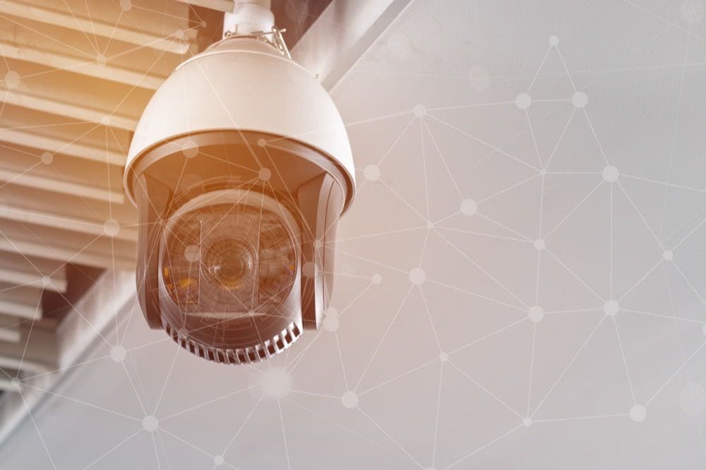 CCTV camera overlaid with a network security interface, representing cyber-physical convergence