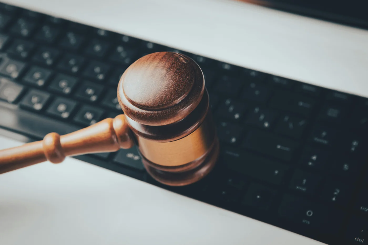Wooden gavel resting on a laptop keyboard