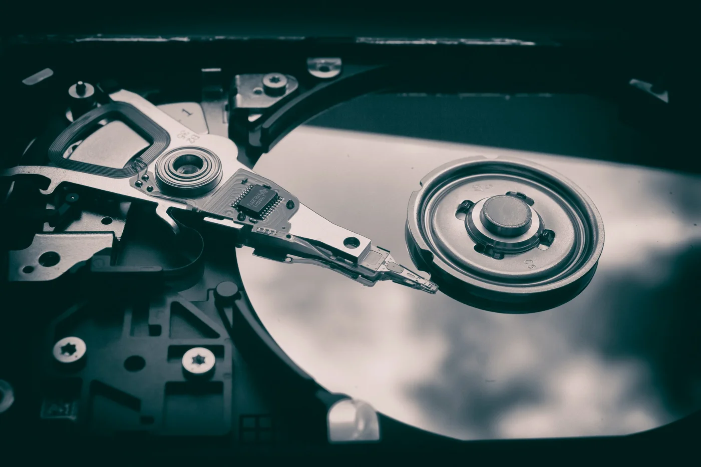 Close-up of an exposed hard disk platter and read arm