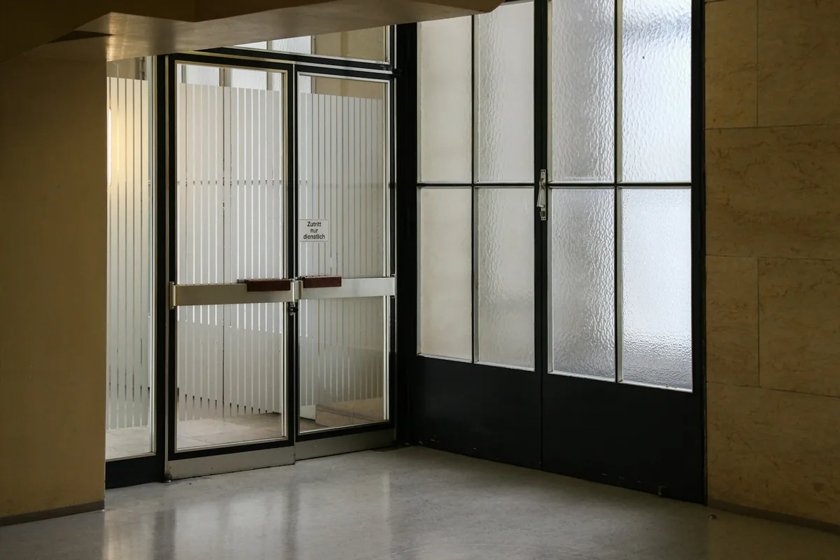 Closed glass entrance doors with metal frames and horizontal push bars.