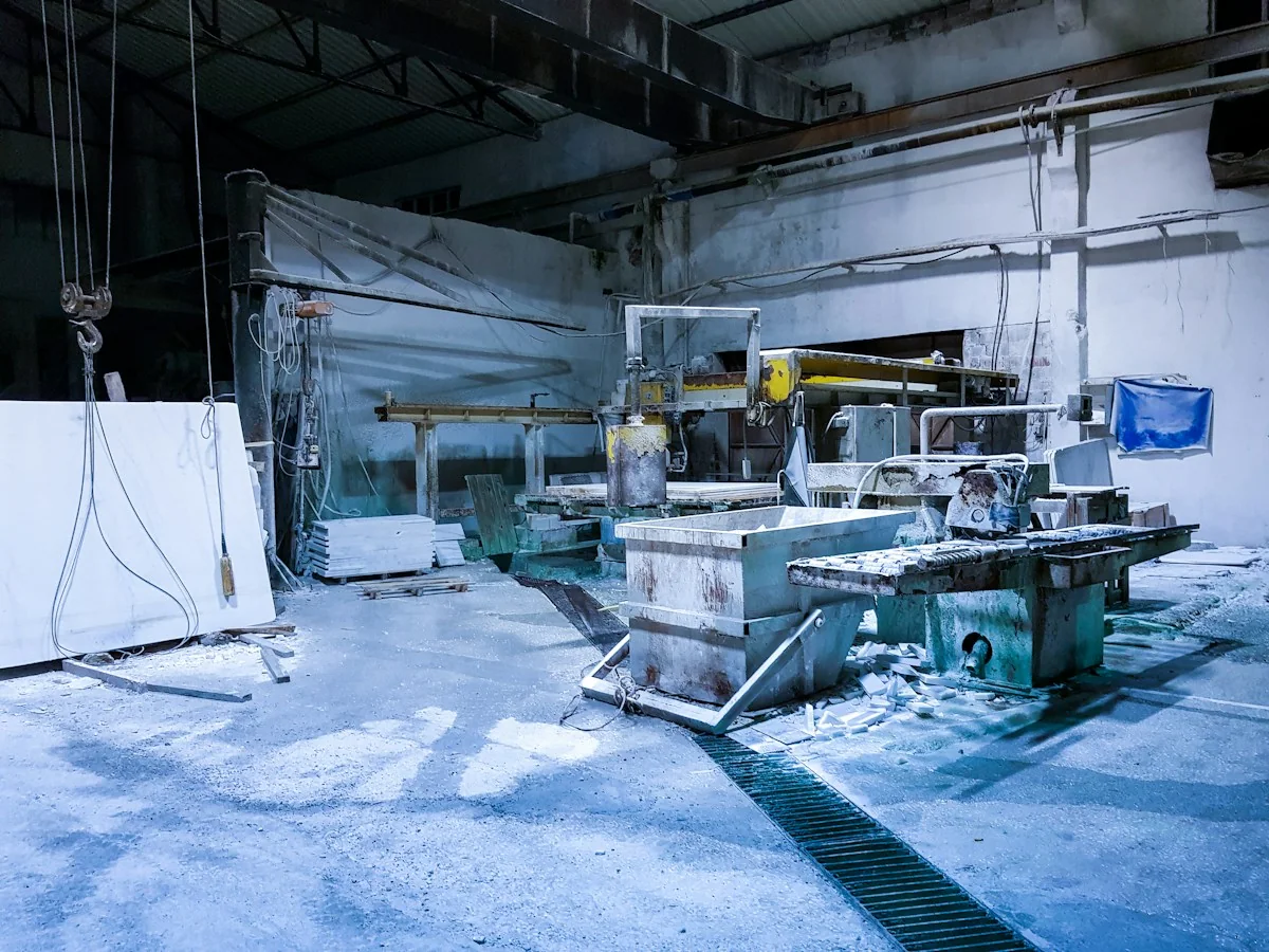 Stone-cutting machinery and work tables inside an industrial workshop.