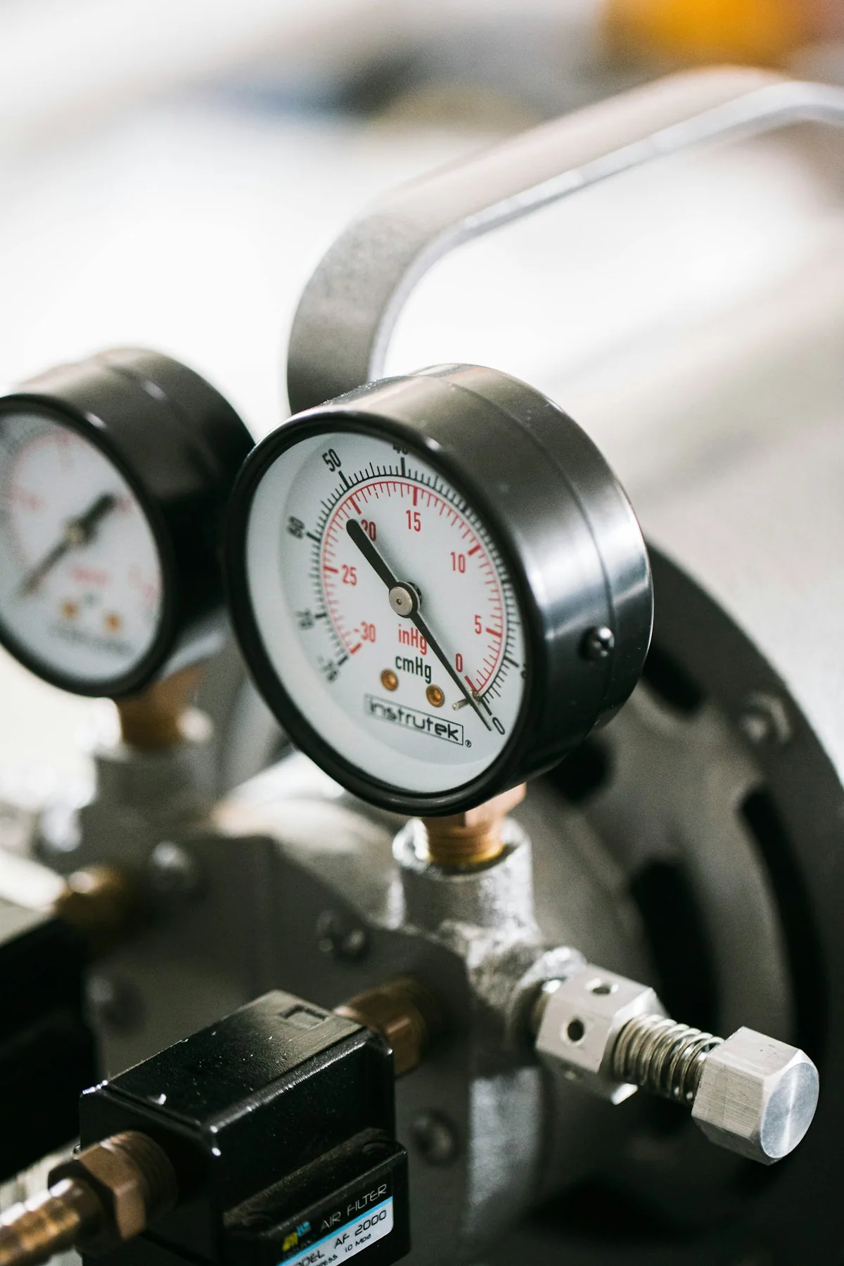 Two analog pressure gauges mounted on a regulator assembly.