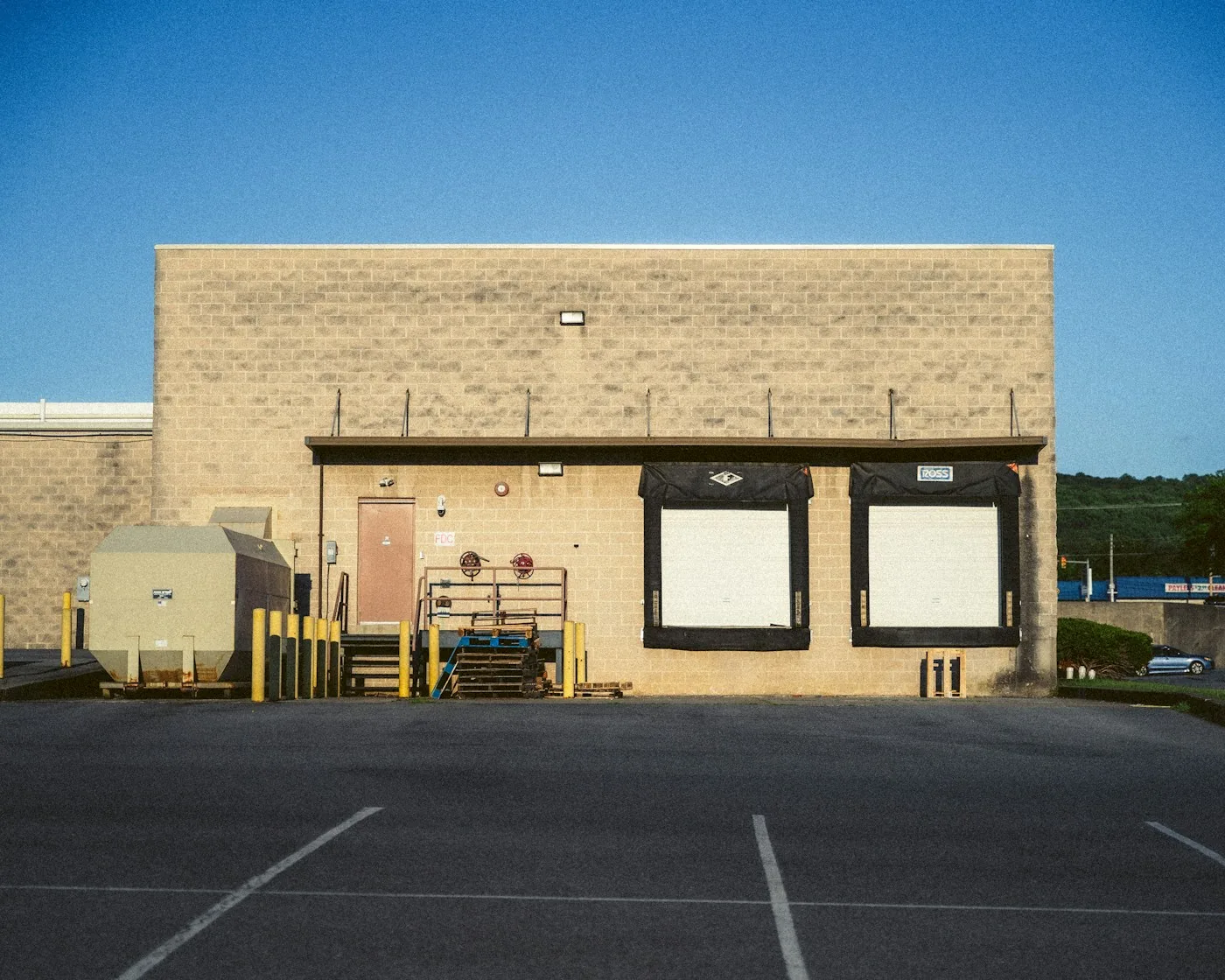 Rear pedestrian door and loading bays on a commercial building.