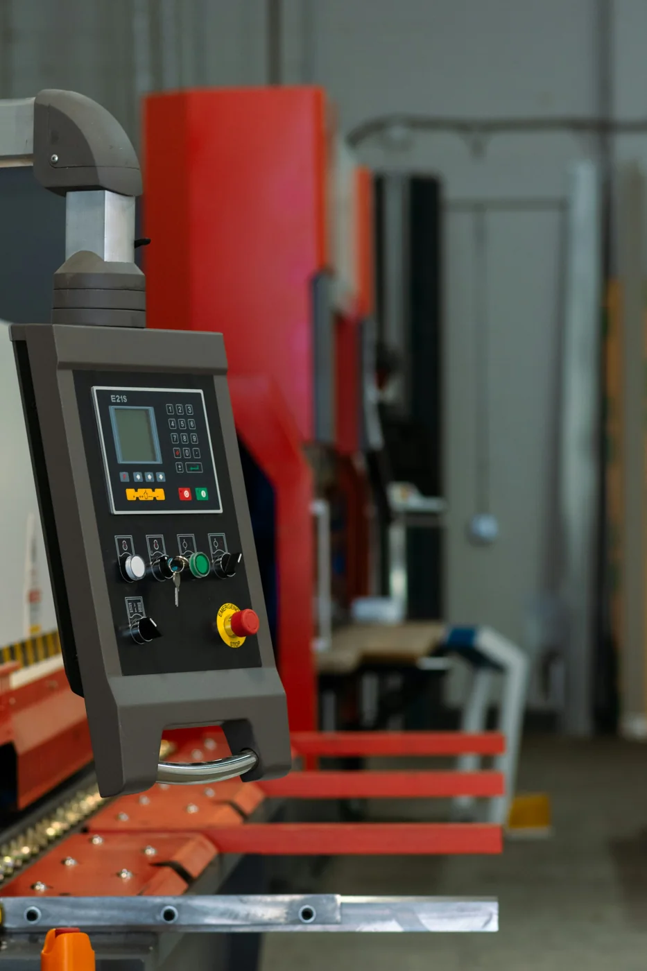 Industrial sheet-metal machine with an operator display beside its work surface.