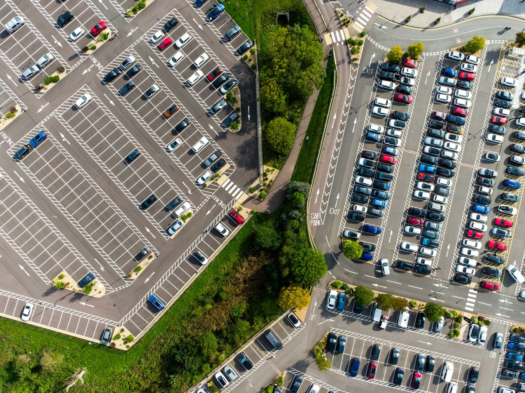 Aerial view of parking areas separated by planted trees and access roads.