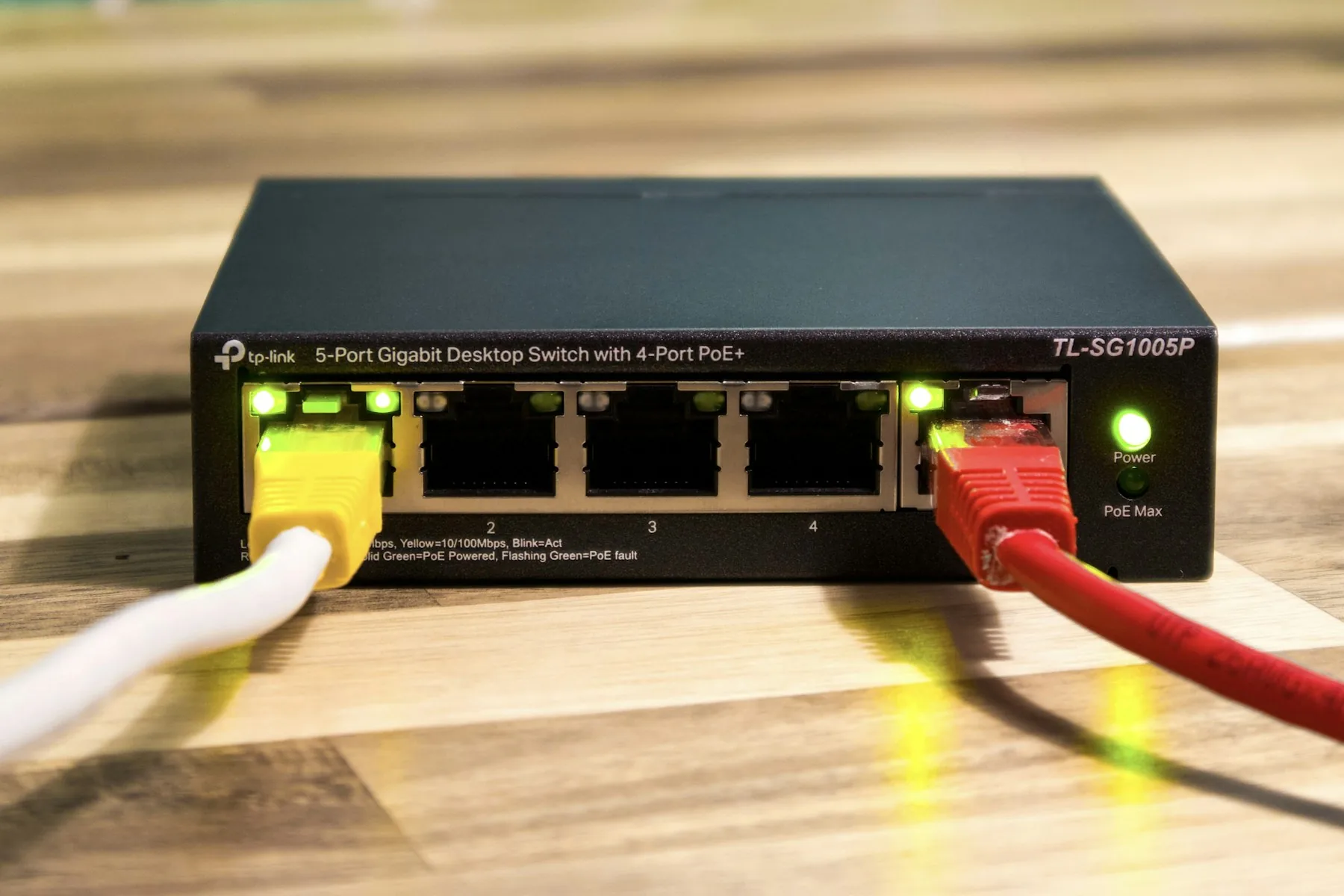 Compact Ethernet switch with connected cables and illuminated power indicators.