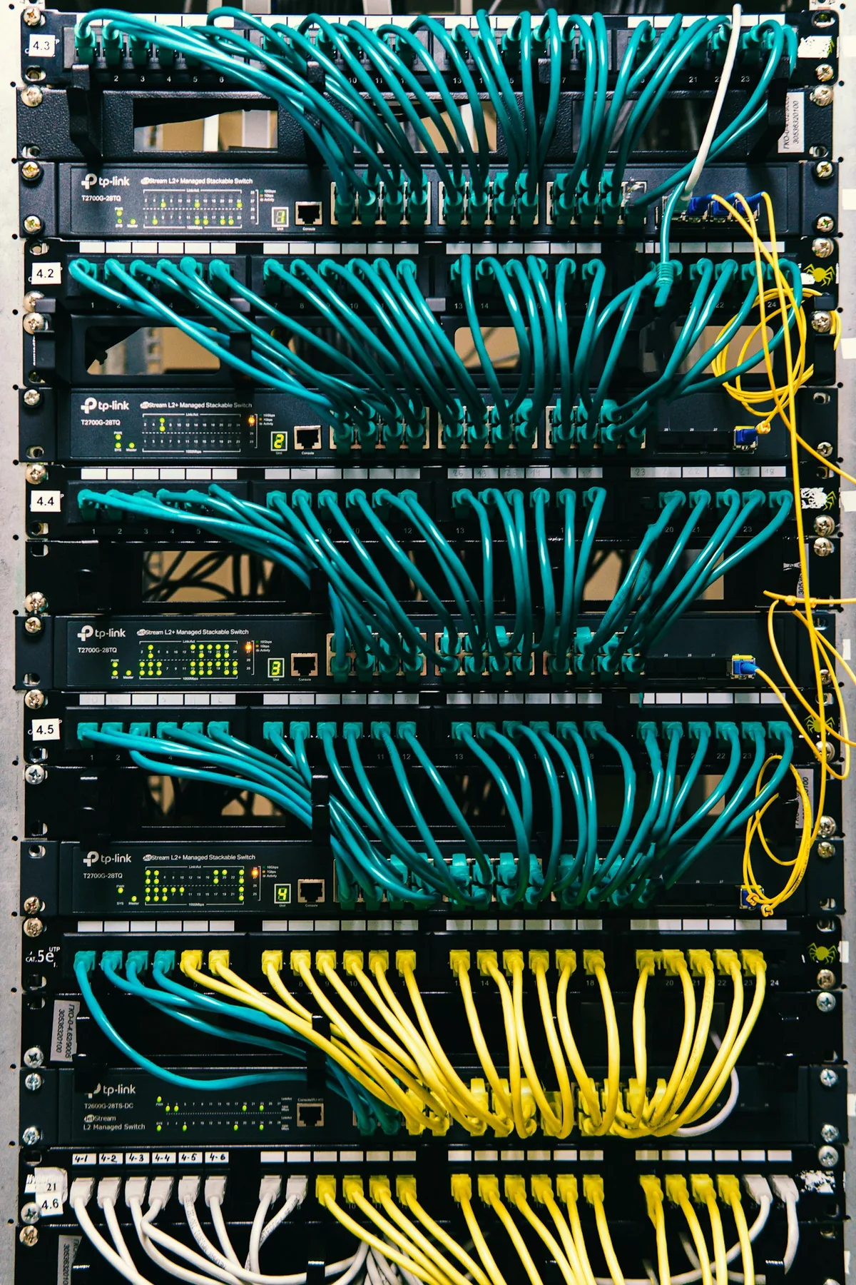 Organized Ethernet patch cables and switches in a network rack.