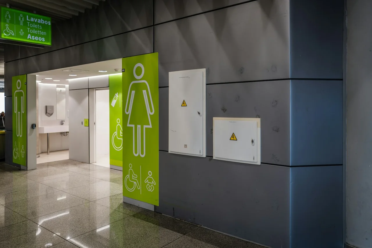Airport restroom entrance with male, female and accessibility pictograms.