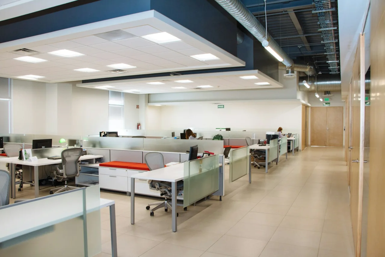 An open-plan office with multiple work areas and suspended ceiling sections.