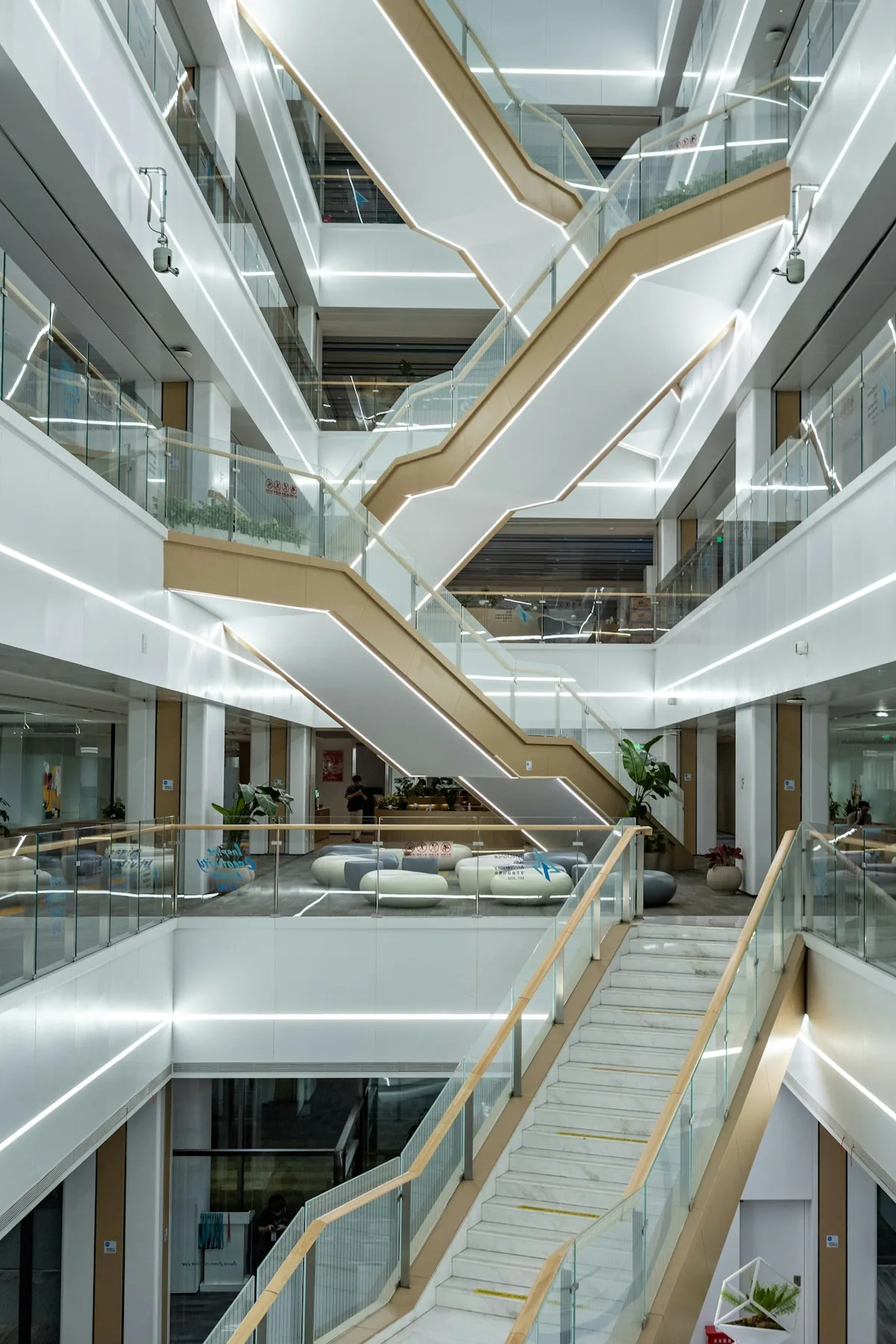 A multi-level office atrium with stairways, glass railings and visible floor openings.