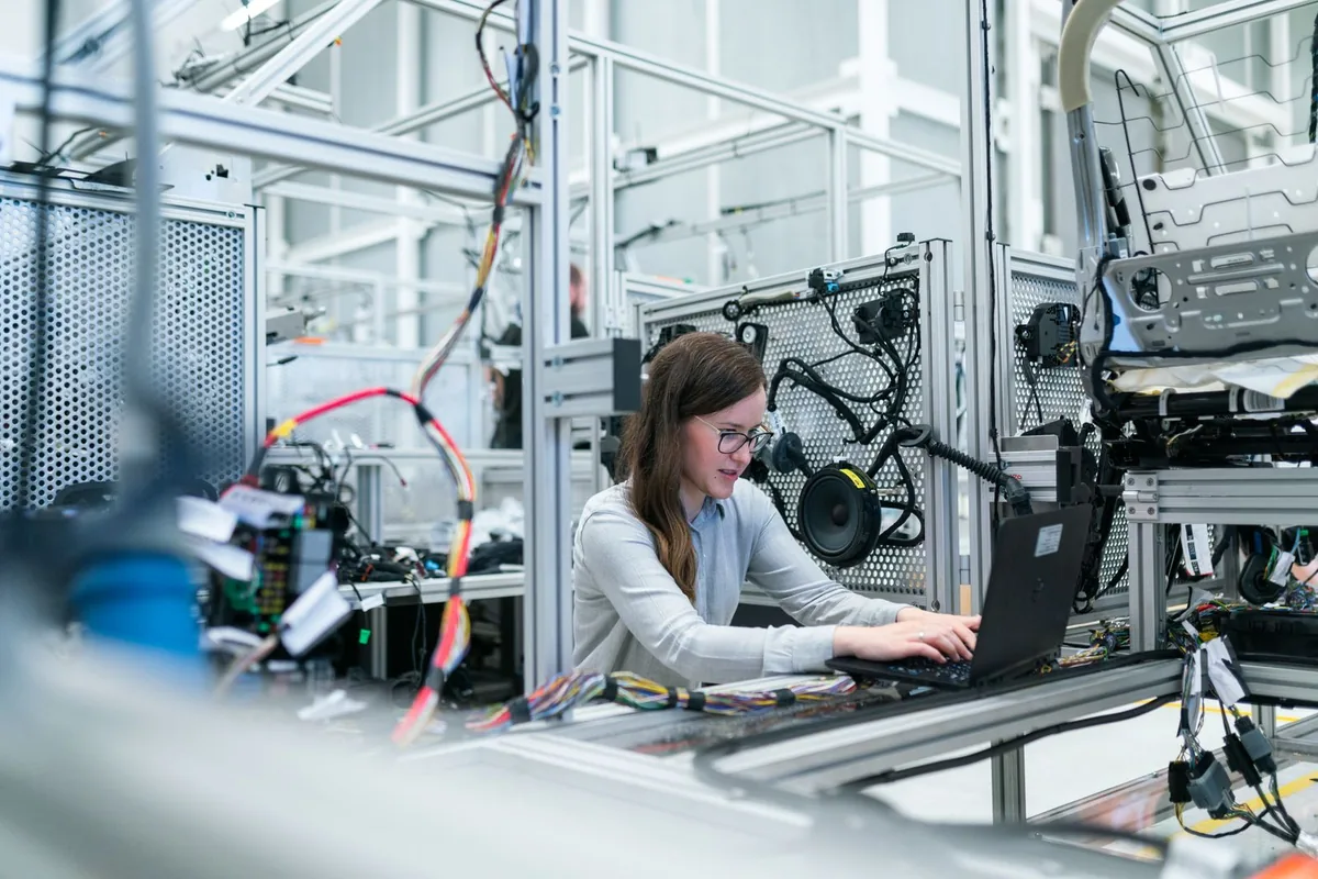 Engineer working on a laptop beside electronic test equipment in a laboratory.