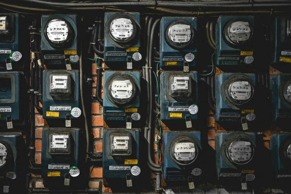 A cabinet containing several analog and digital electricity-meter models.
