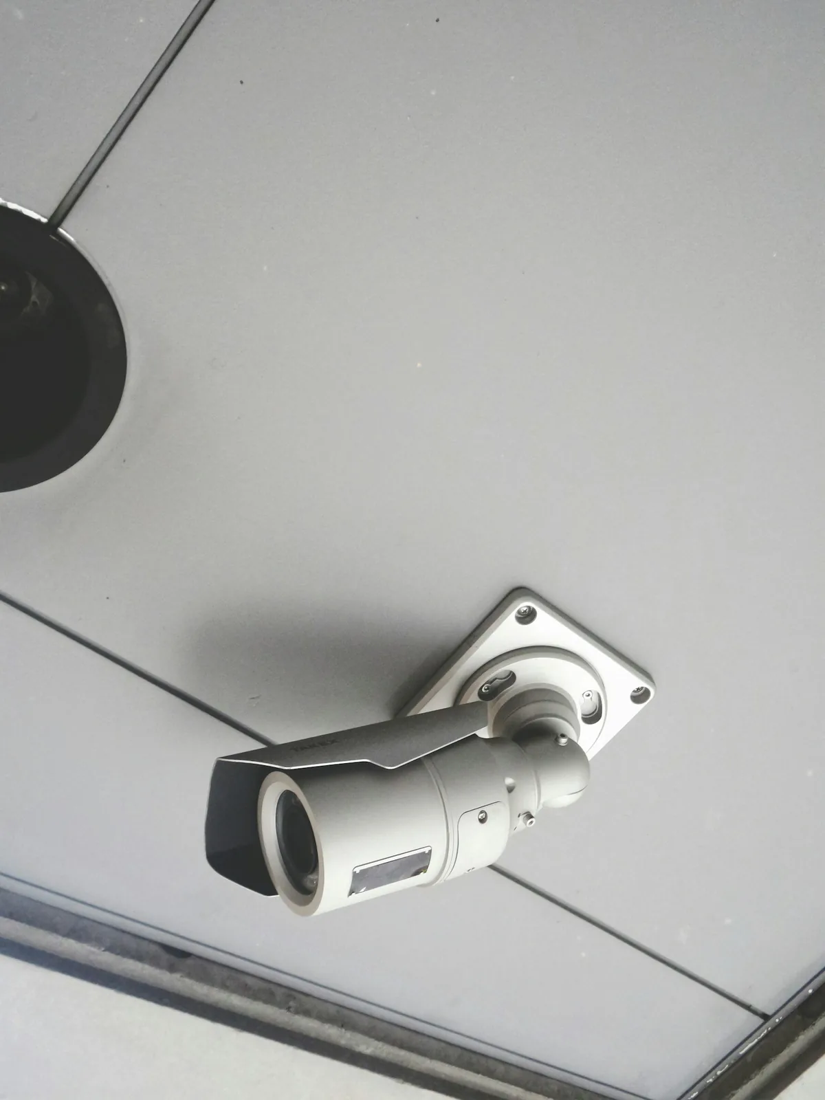 A security camera mounted on the ceiling of an interior space.