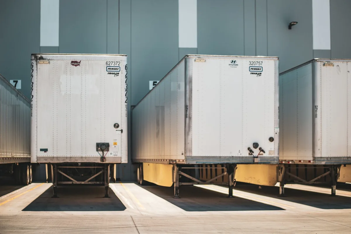 Semi-trailers backed into loading bays at a warehouse.