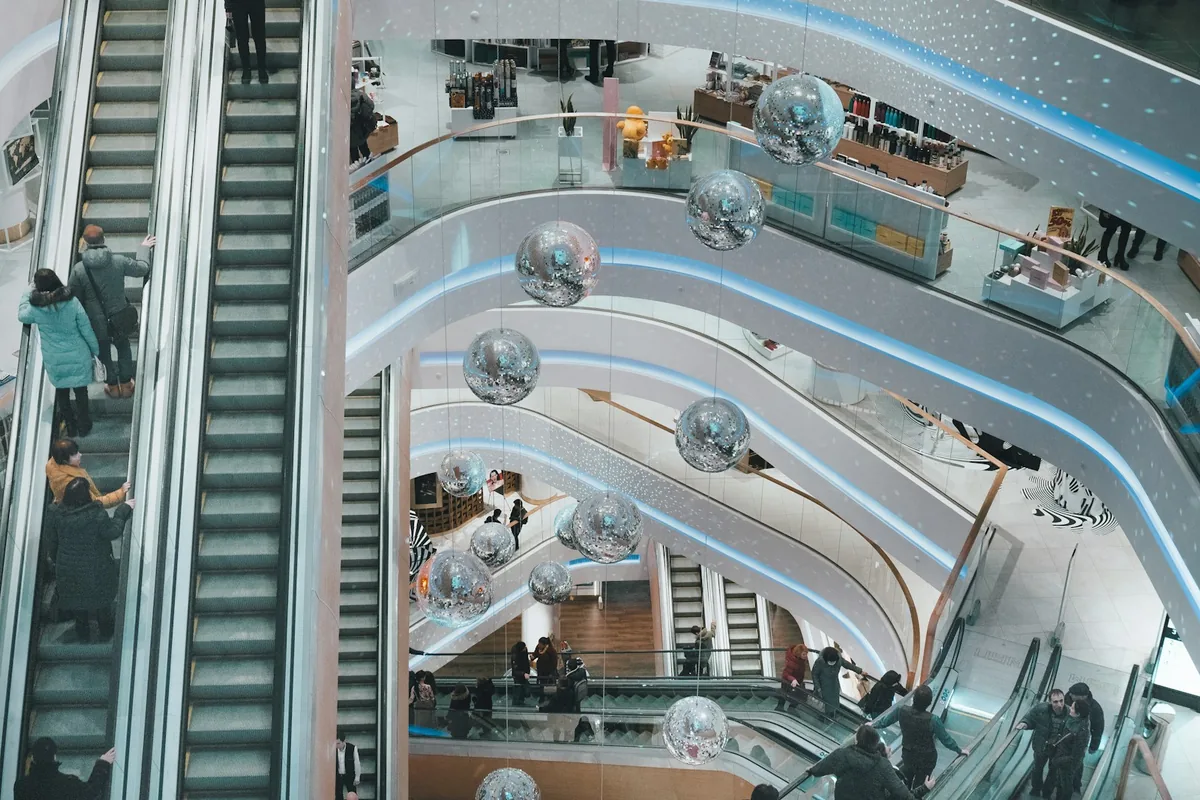 An elevated view across several floors and escalators of a shopping mall.