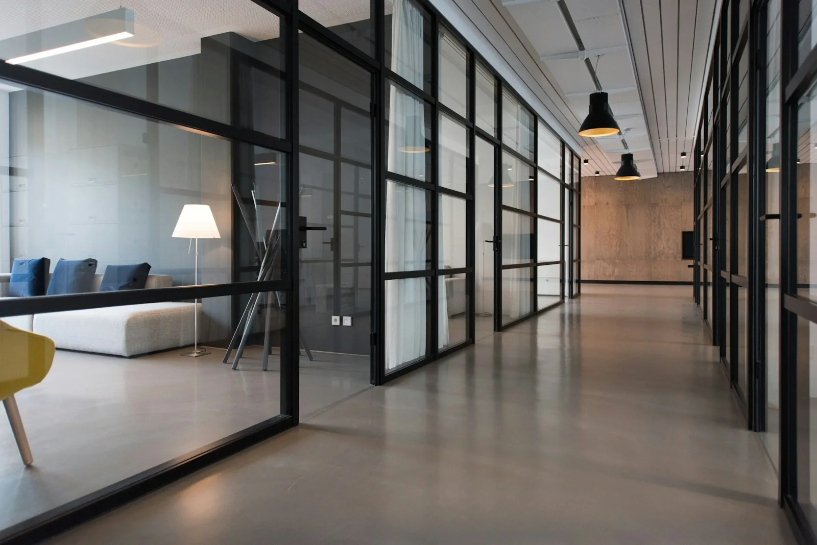 Glass-walled offices opening onto a quiet corridor.
