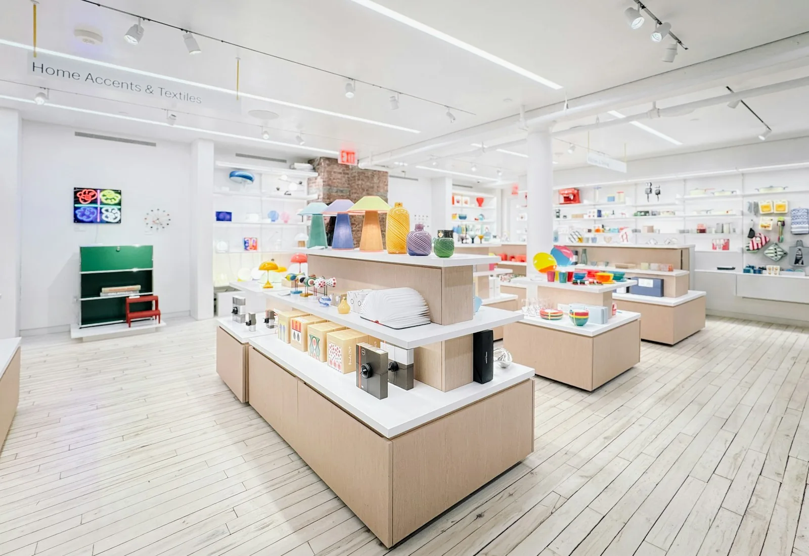 A bright retail interior with display tables and ceiling ventilation grilles.