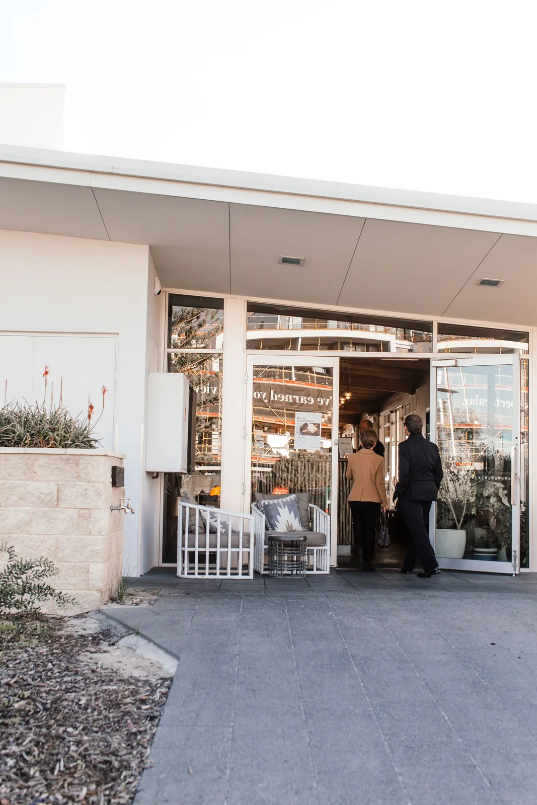 People at the open glass entrance of a small retail store.