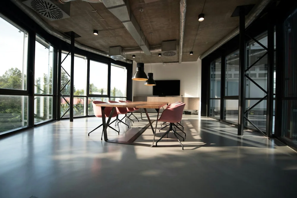 Meeting room with visible ceiling ventilation ducts and diffusers above a conference table.